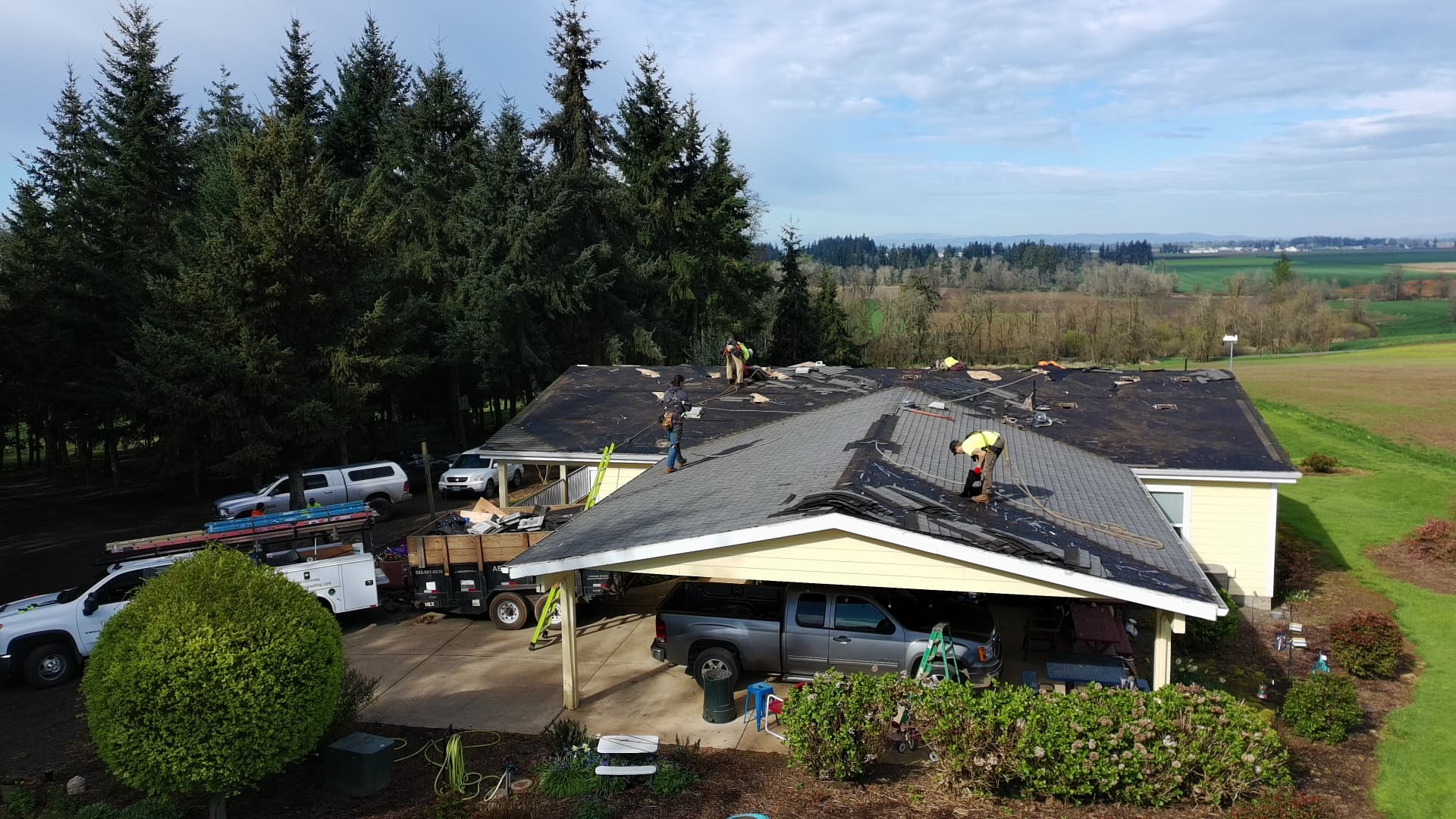 Crew members working a tear-off on a rural home overlooking Willamette Valley farmland